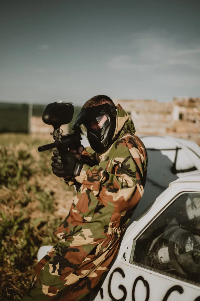 paintball player leaned car